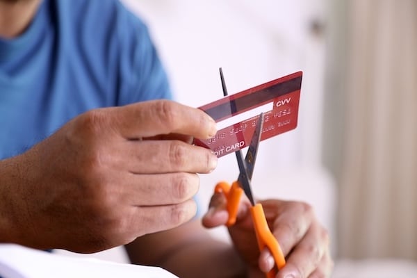 Stop Using Credit Card; Close up of scissors cutting credit card