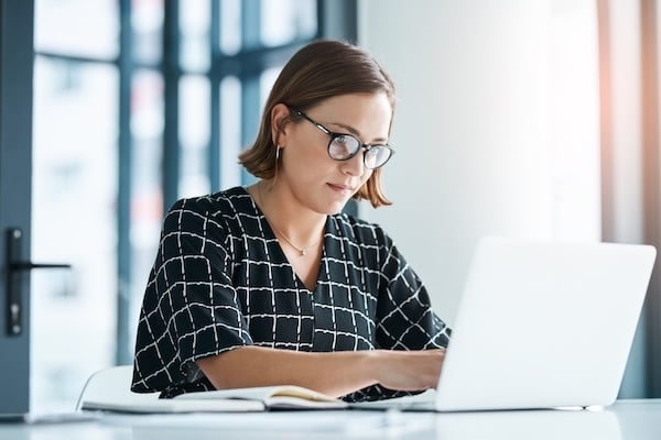 woman_typing_on_laptop_working_in_office_submitting_online_application