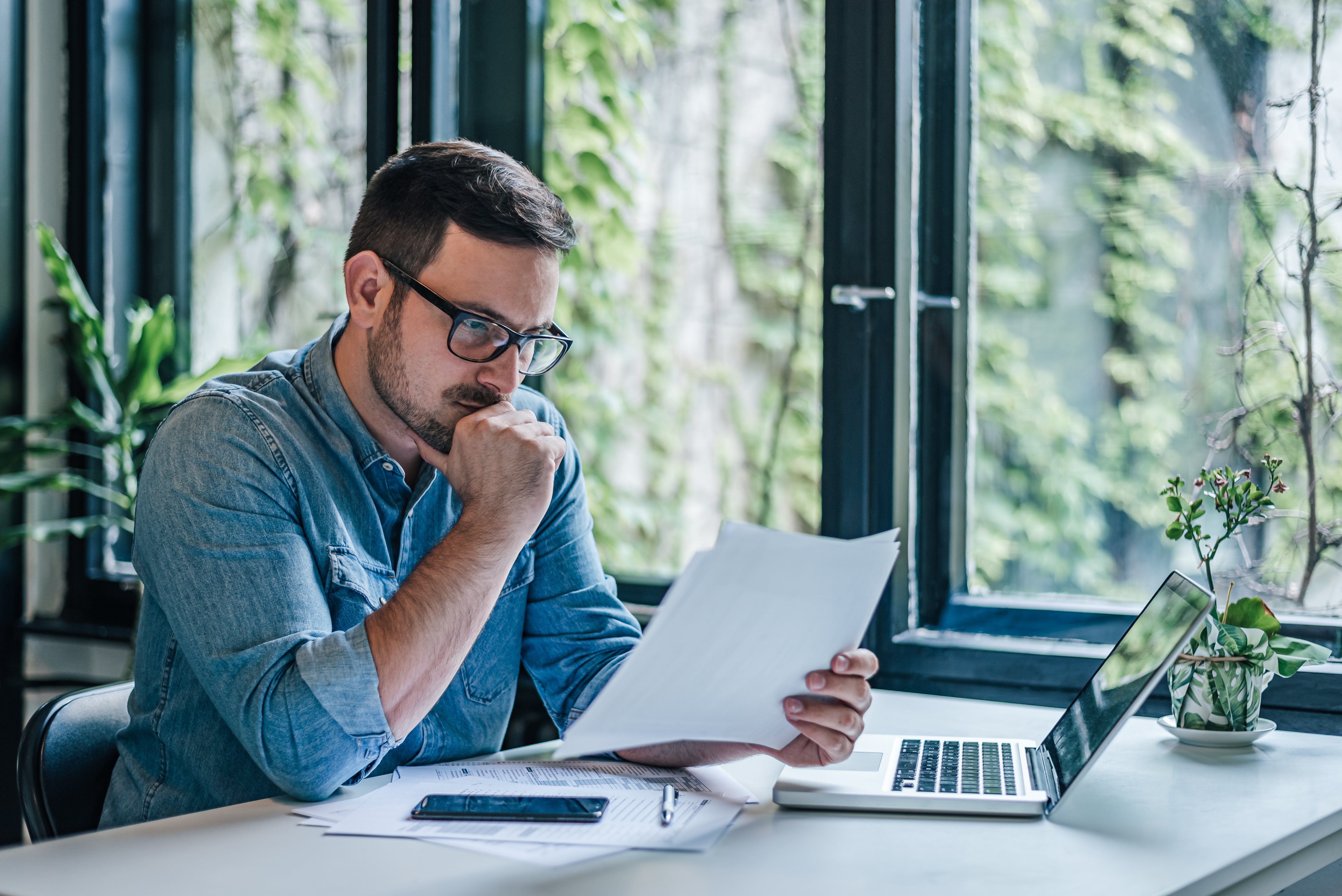 business_man_analyzing_document_reviewing_interest_rates_loan_terms