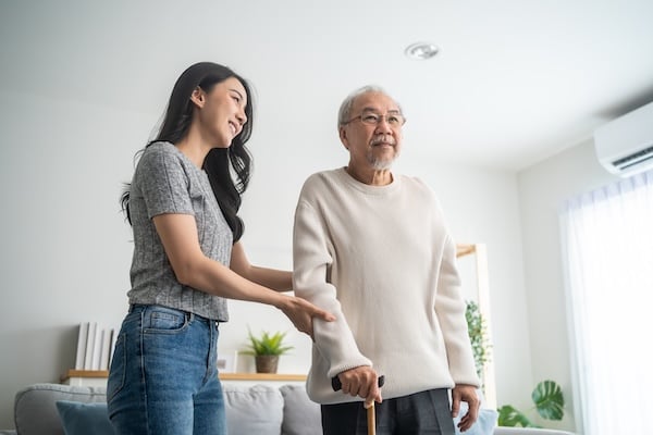 Asian young daughter support senior older man walk with walker at home adobe stock photo