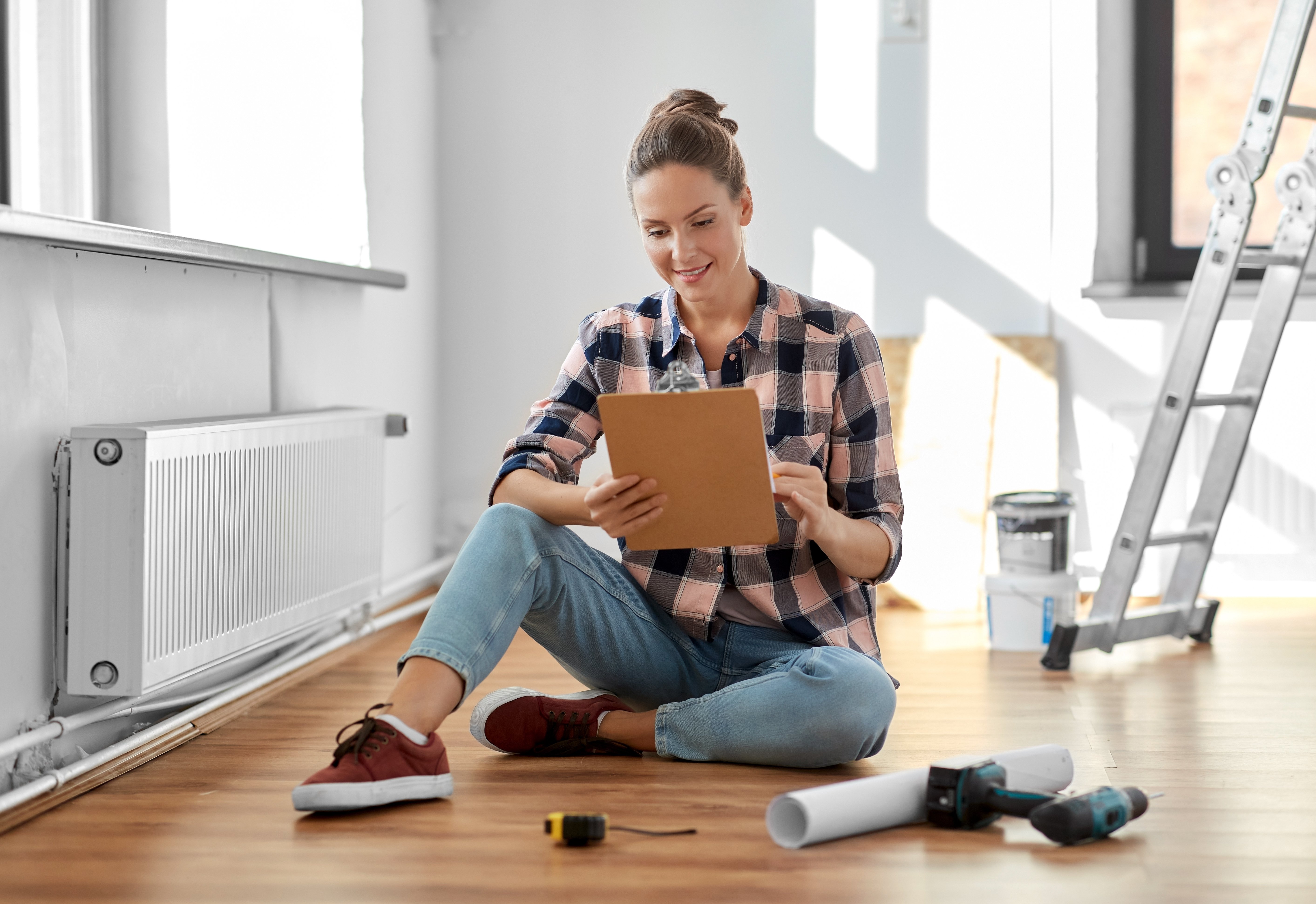 woman with clipboard sitting on floor at home adobe stock photo