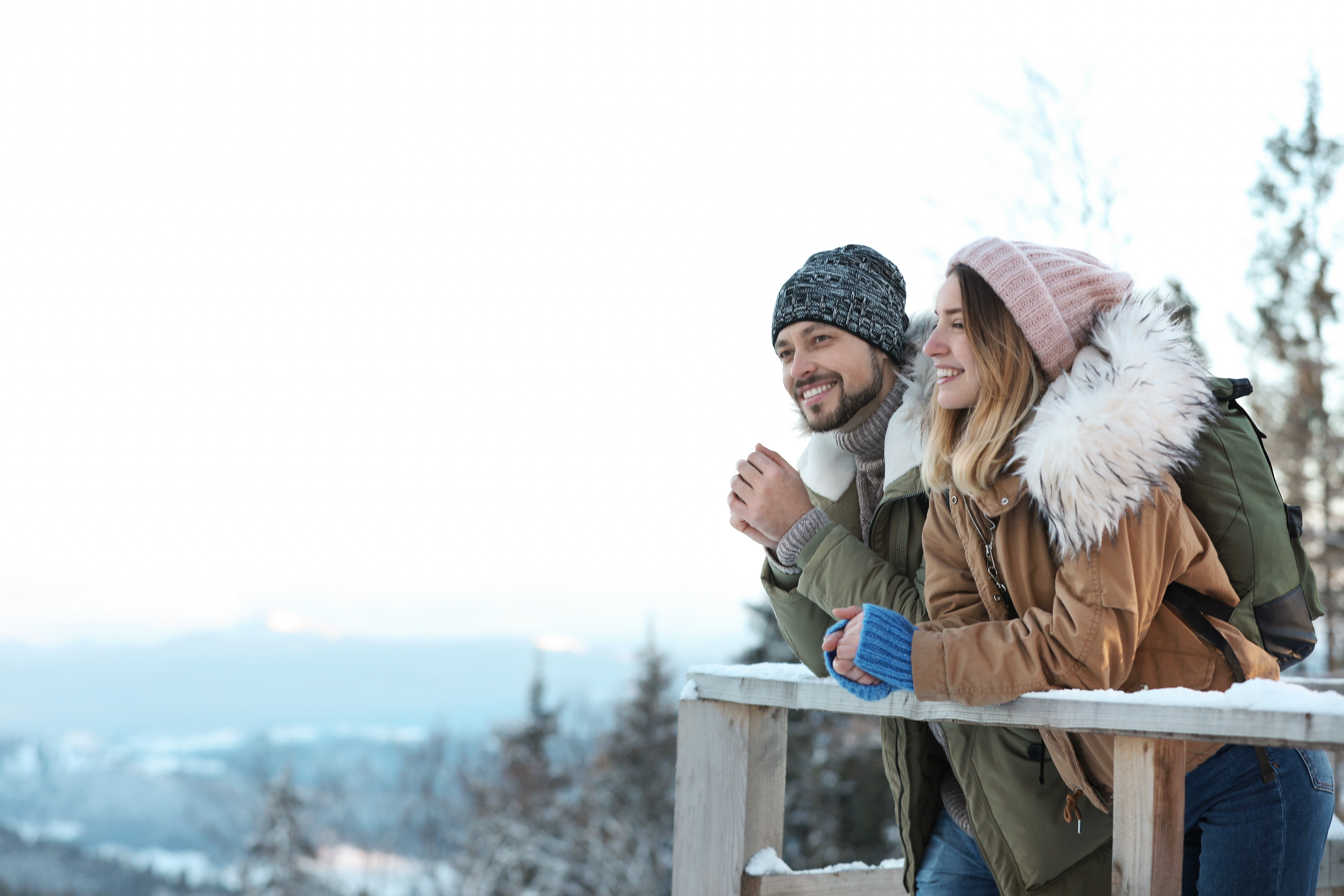Couple with backpacks enjoying mountain view during winter vacation