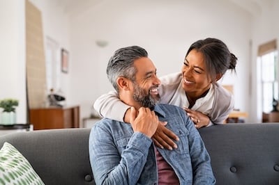 Mature multiethnic couple laughing and embracing at home adobe stock image