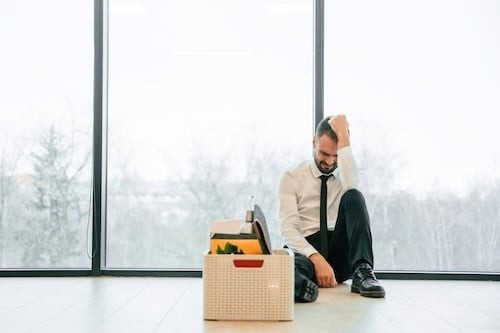 Sad Businessman Sits with His Belongings after Layoff