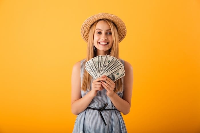 Portrait of a happy young blonde woman in summer hat