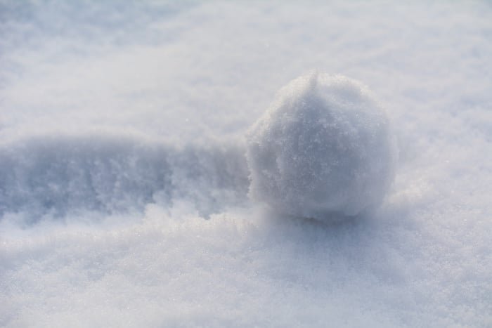 the snowball rolls over the snow; close up; selective focus