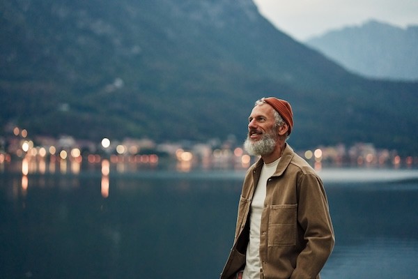 Happy older man standing in nature park enjoying natural park landscape