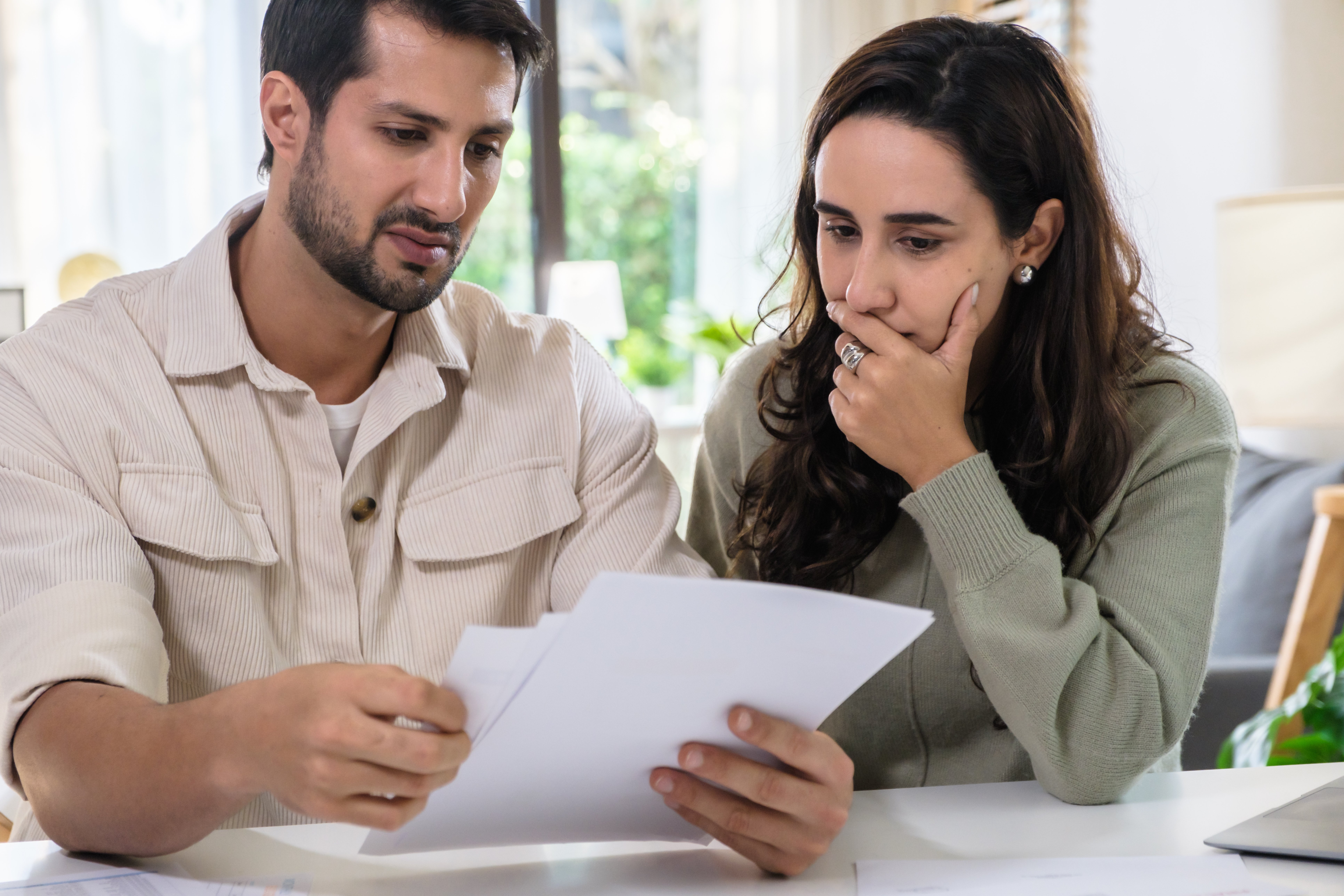Couple overwhelmed by overdue bills and low income, facing economic stress and inflation-related financial crisis Adobe stock photo