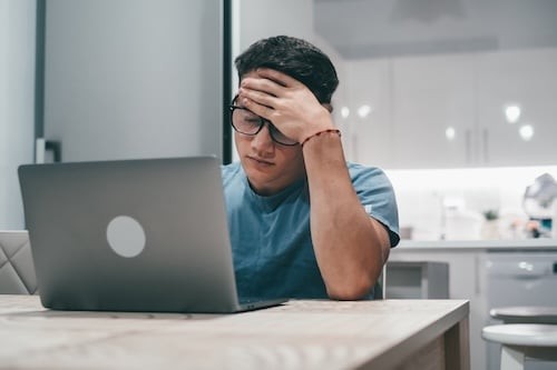 Stressed Young Man Working on Laptop at Home