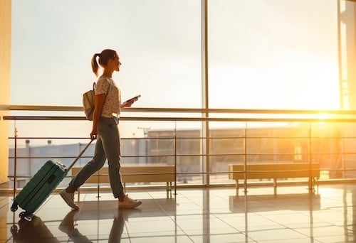 woman walking through airport traveling opportunity adobe stock image