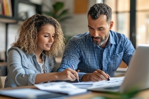 Financial Adviser Assisting Recent Graduate with Student Loan Repayment in Modern Office Setting - Medium Shot