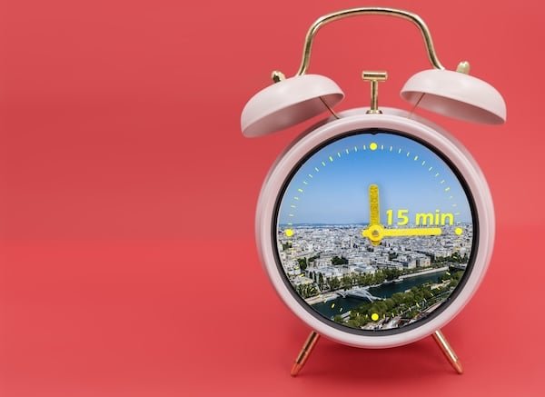 Ringing twin bell vintage classic alarm clock Isolated on red and with the 15 minute city concept.
