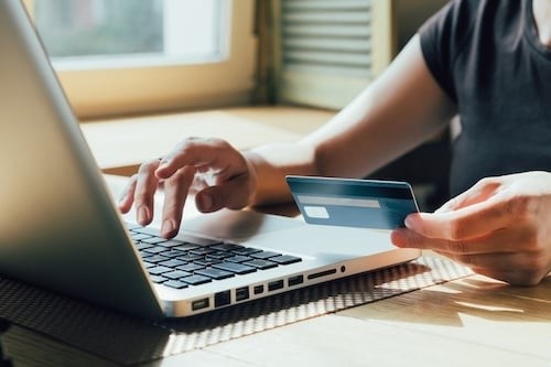 girl makes a purchase on the Internet on the computer with credit card