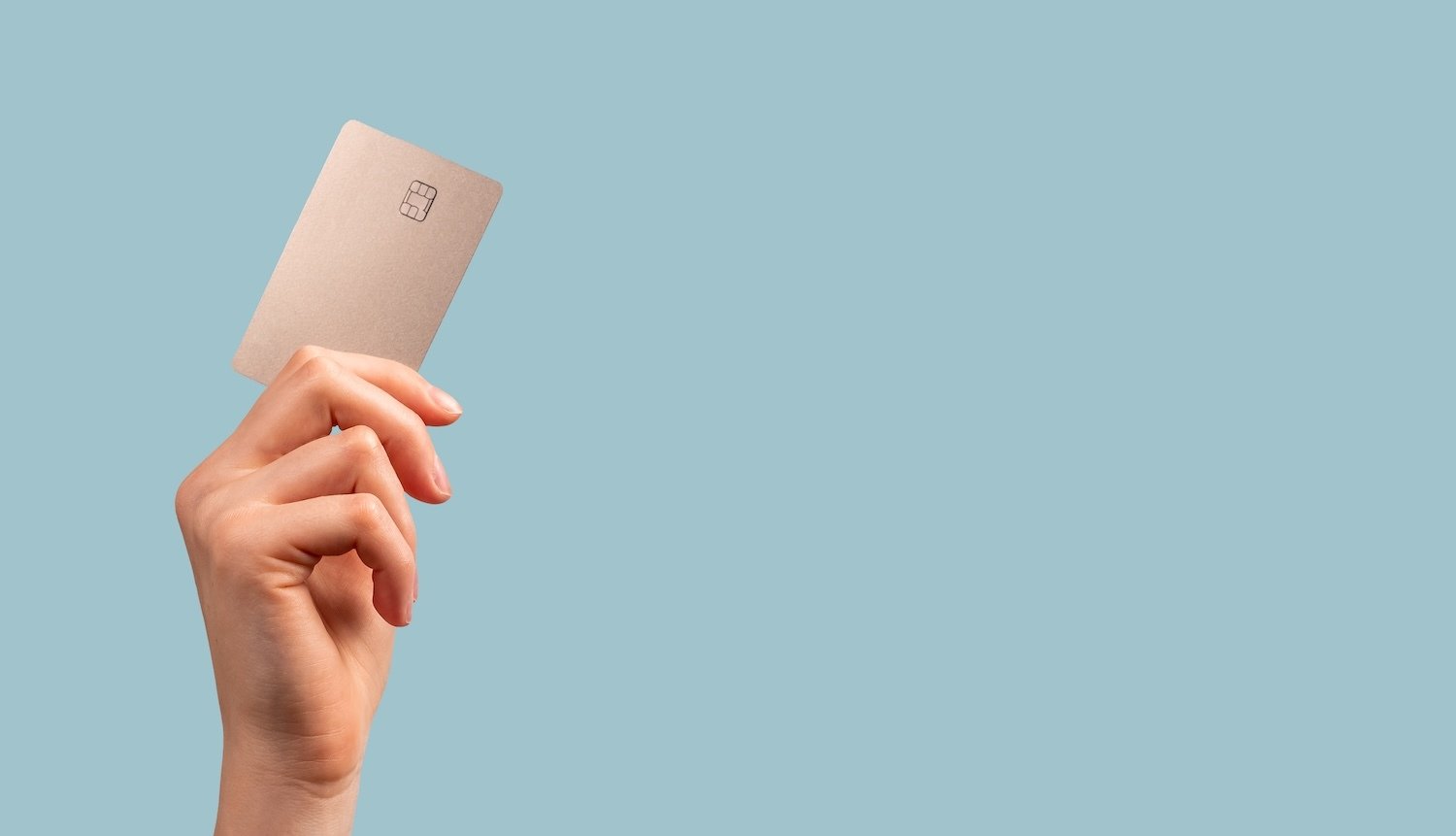 Banner with hand holding credit card mockup with chip on blue background.