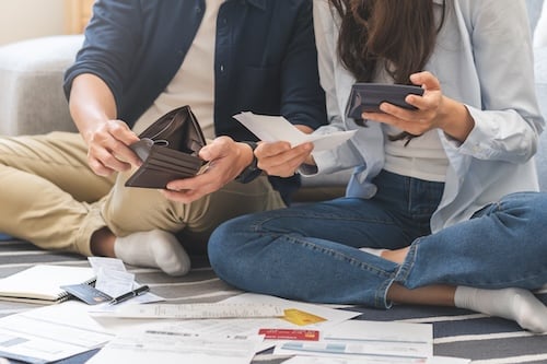 Stressed financial owe asian young couple love sitting stressed and confused by hand hold wallet calculate expense from invoice , no money to pay, mortgage or loan. 