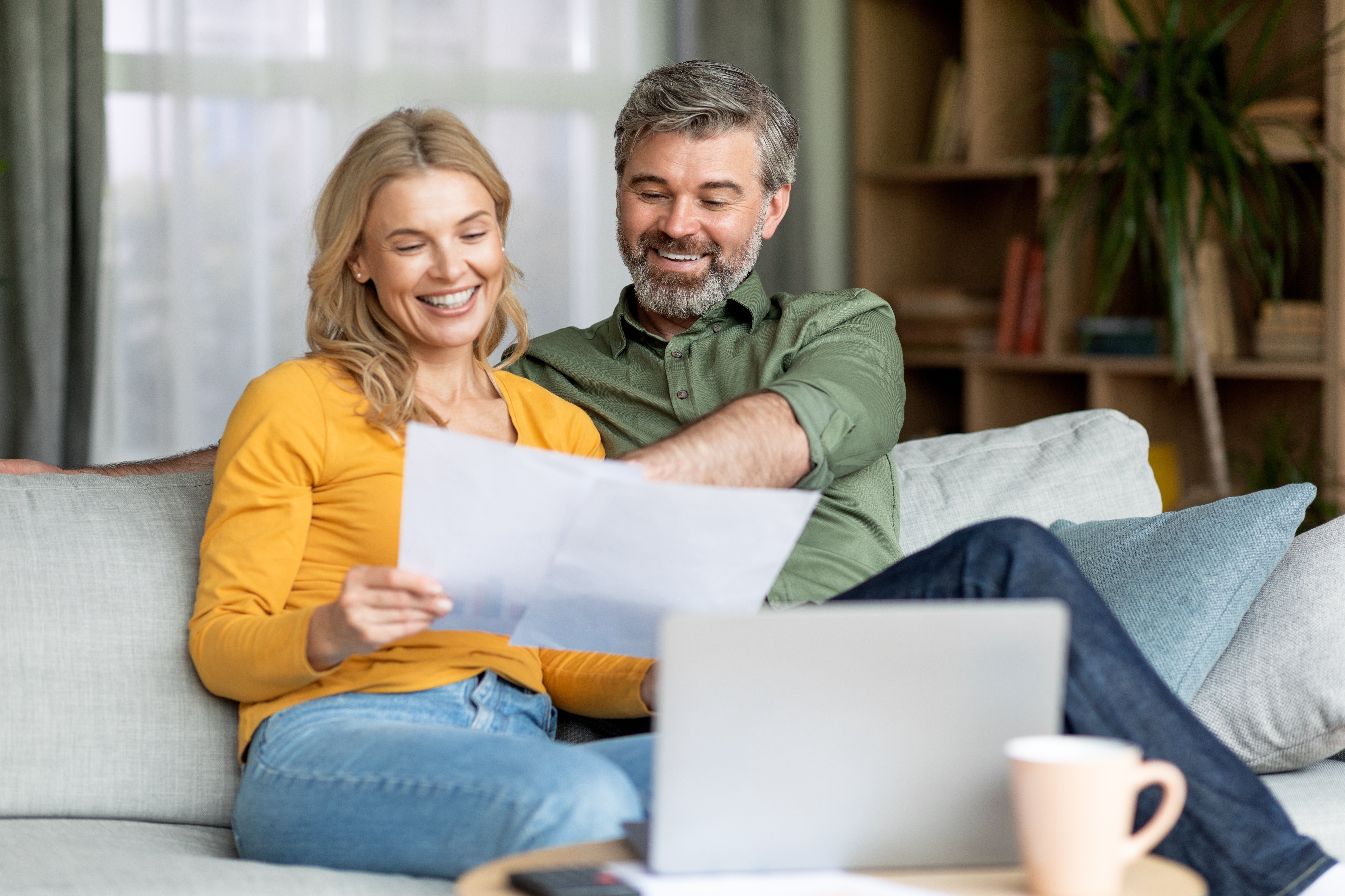Happy Middle Aged Couple Reading Documents At Home Adobe stock photo