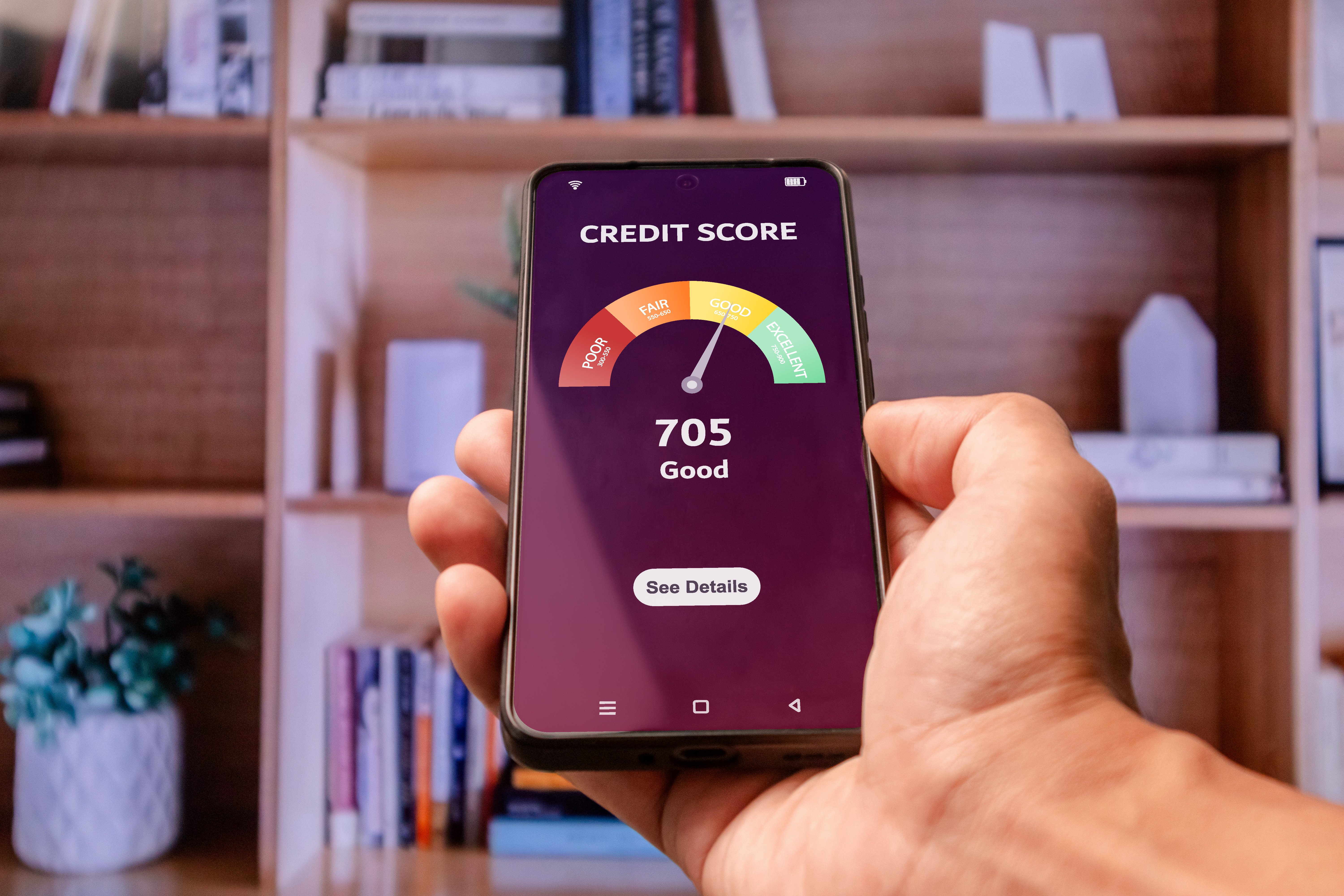 Hand holding a smartphone to check credit score to apply for loan