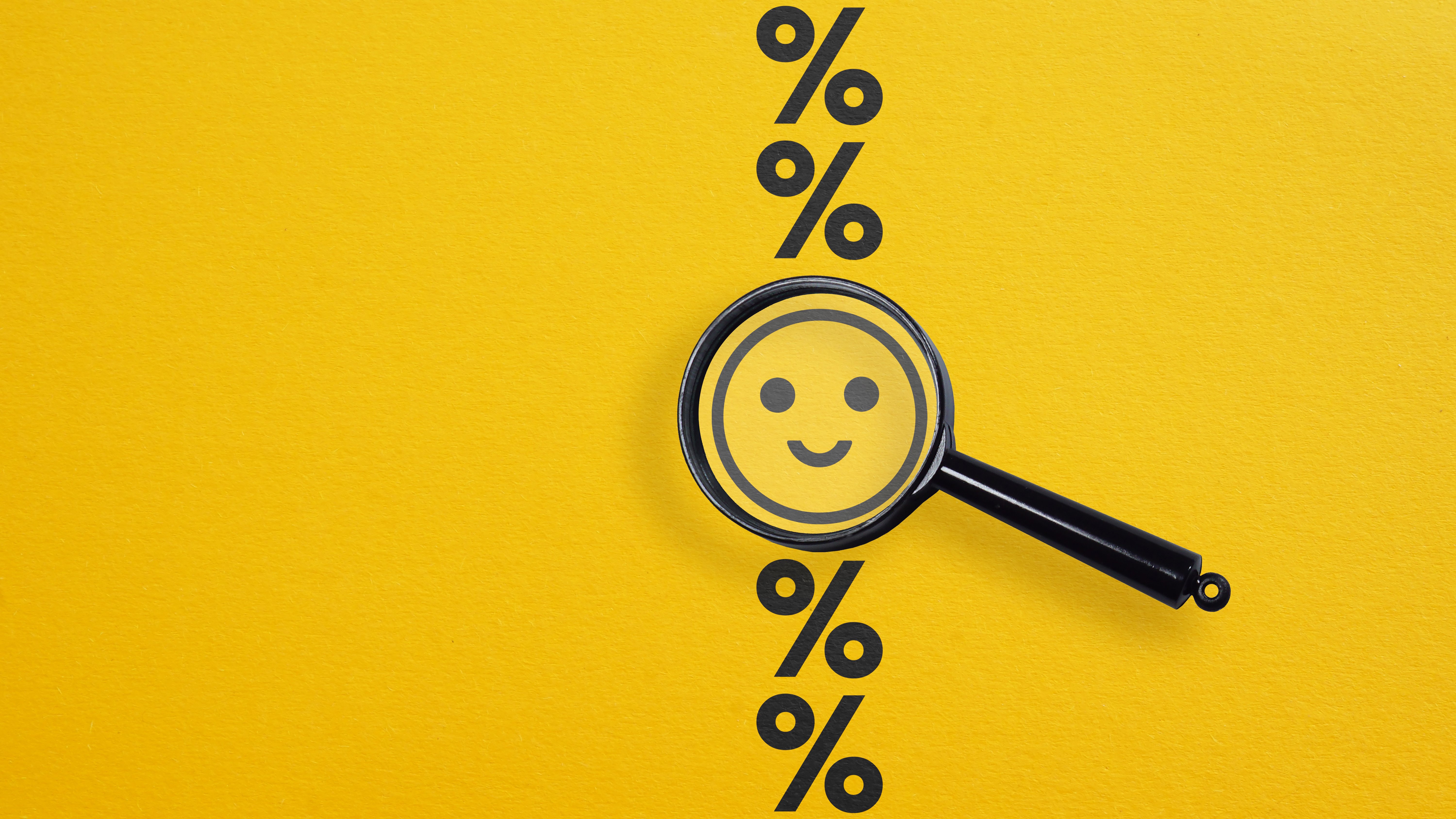 yellow_background_with_pecentage_signs_smiley_face_in_the_middle_of_a_magnifying_glass